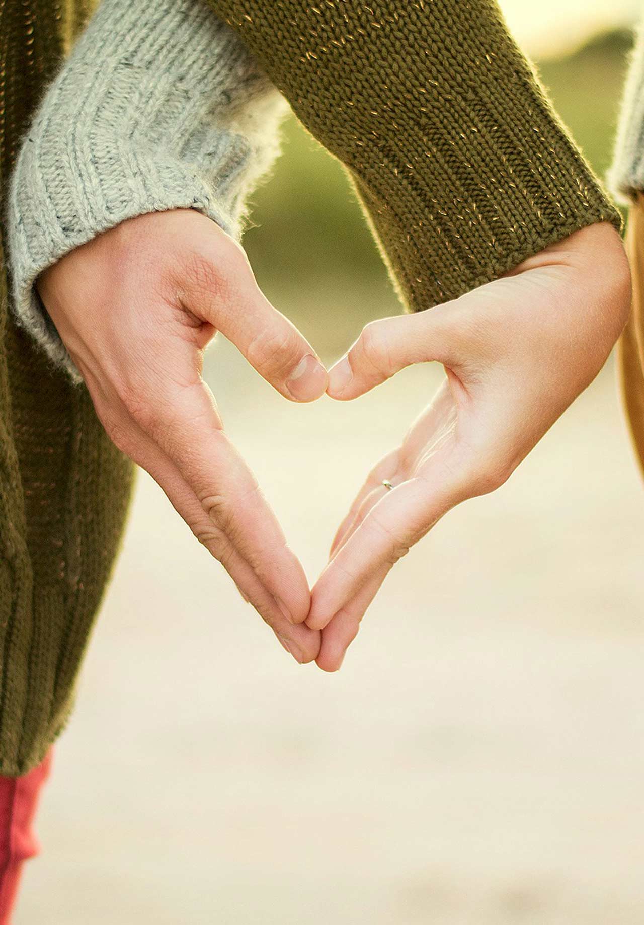 couple makes a heart shape with fingers